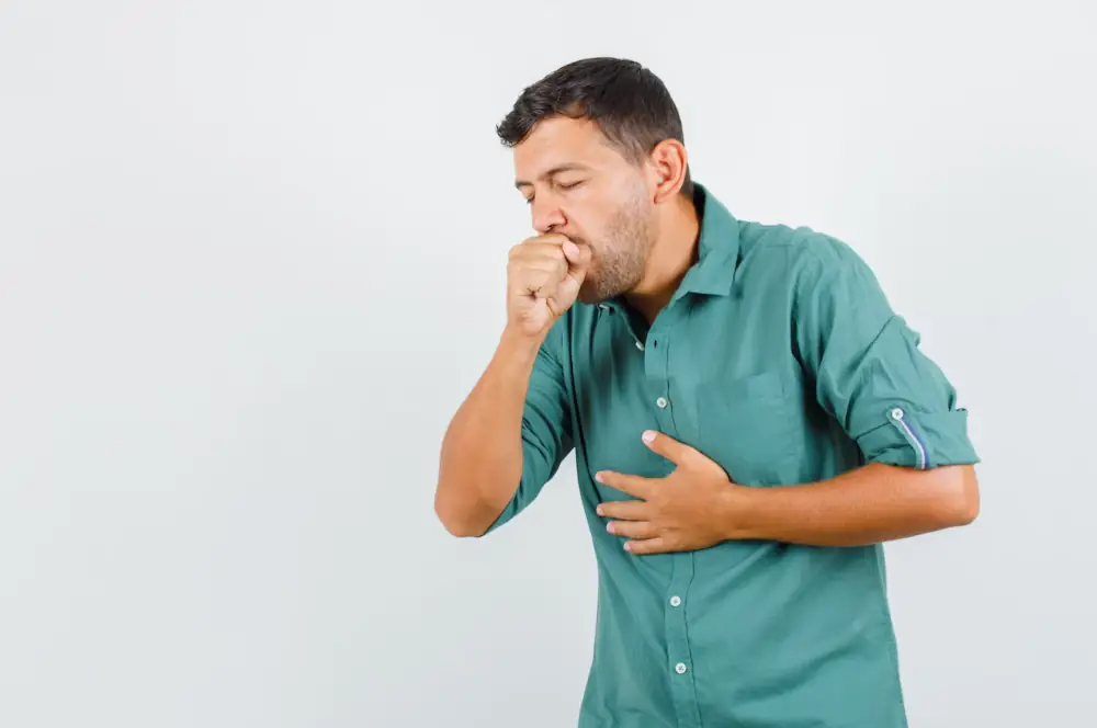 Man coughing and holding chest, showing symptoms of lung or respiratory problem